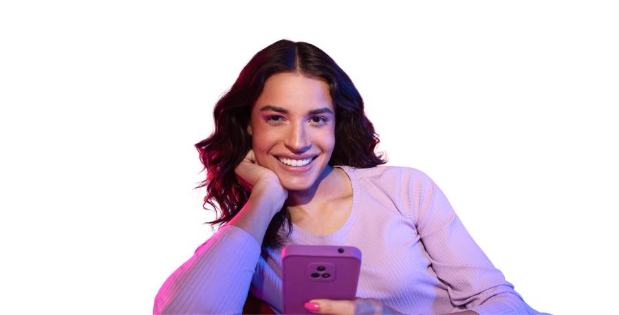 imagem de uma mulher sorrindo, segurando um celular em uma mão, e a outra apoiada no queixo